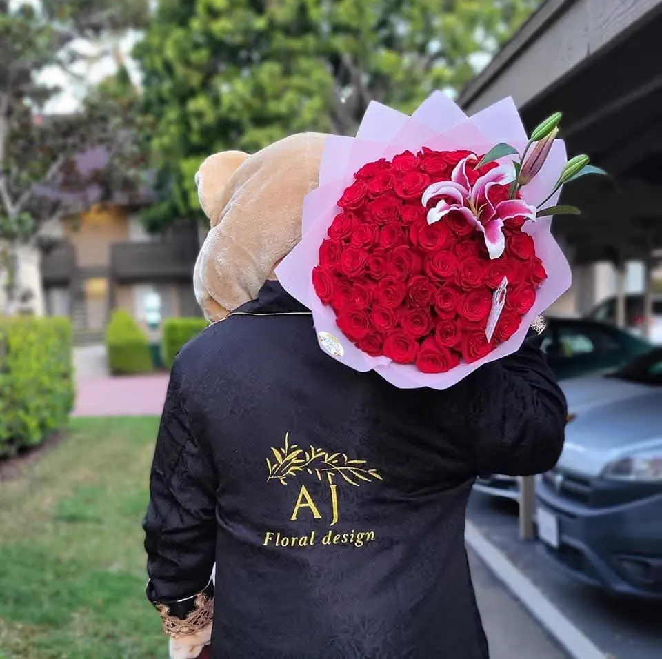 Ana con su chamarra de AJ Floral Design y un ramo de rosas